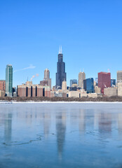 Fototapeta na wymiar Big city skyline along frozen lakeshore in winter