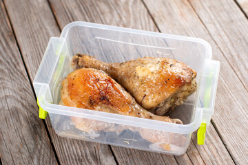 Baked chicken legs in a container. Ready meals