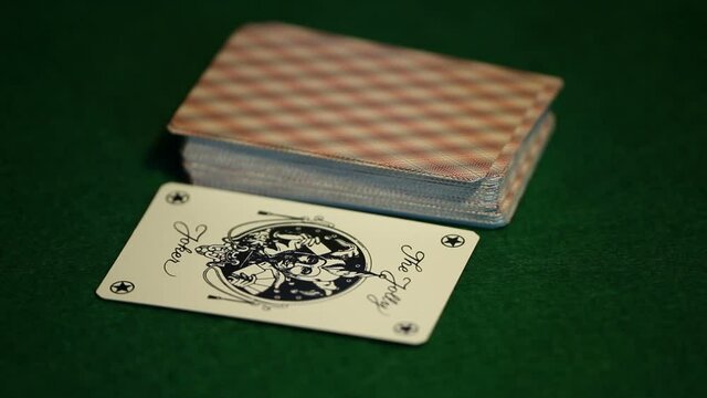 card player takes out a joker card from the deck of cards close-up
