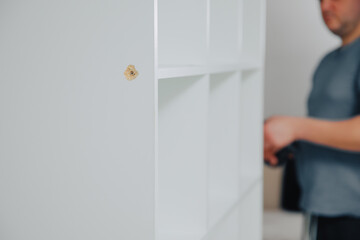 White cabinet is assembled. Damage when building a cabinet. Assemble furniture yourself at home 