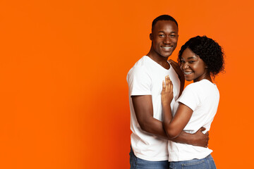 Obraz premium Cute african american couple hugging and smiling at camera