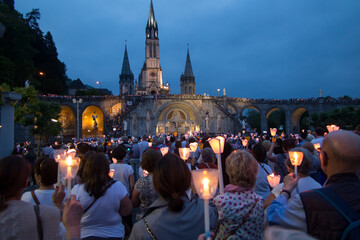 Lourdes, France, 24 June 2019: Evening procession with candles at the shrine of Lourdes - obrazy, fototapety, plakaty