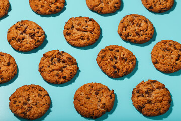 Oatmeal cookies with chocolate chip pattern and patterns on a light blue background. Full screen, top view