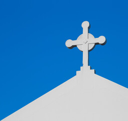White church cross against a bright blue sky, Vicentine Coast, Alentejo, Portugal.