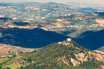 Fototapeta na wymiar Panoramic view of the landscape surrounding the Republic of San Marino with the Castle of Montebello di Torriana in the foreground, Italy