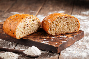 Side view on cut loaf of rustic bread with filling on the wooden table