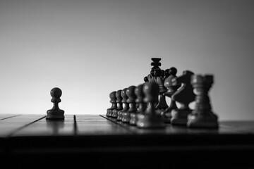 Chess board with chess pieces silhuettes on white background. Concept of business ideas and competition and strategy ideas. Black and White classic art photo. Traditional king's pawn opening. 