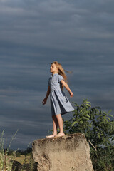 A little girl imagines that she is flying. Blue sky and warm wind. The happiness and happiness of a...