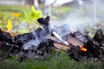 Burning books on the hearth outdoors, forbidden books