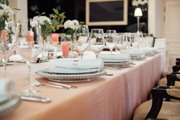 Luxurious restaurant. Luxurious interior, white tables, serving dishes and glasses for guests