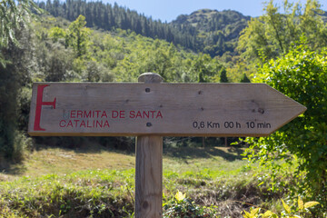 Wooden sign points to Santa Catalina Hermitage (Ermita de Santa Catalina) chapel near Santo Toribio de Liebana monastery, Potes, Picos de Europa mountains, Spain.