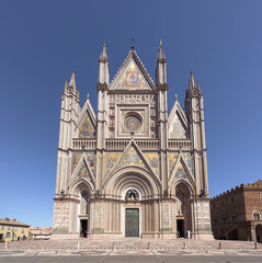 Fototapeta na wymiar Renaissance facade of Orvieto cathedral, with rose window and gothic style spires and sculptures, a famous landmark in Orvieto medieval town in Umbria, Italy