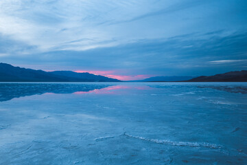 Blue hour with pink sunset at wet salt field of Death Valley 