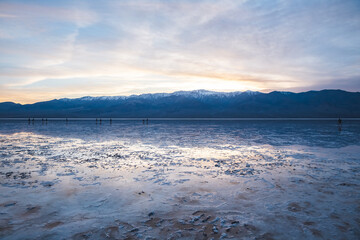 Sunset at wet salt flats of Badwater in Death Valley, California