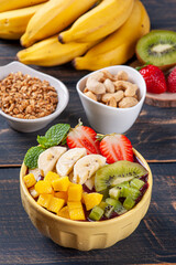 .Brazilian açaí in a bowl accompanied by tropical fruits. Fruit of the Amazon