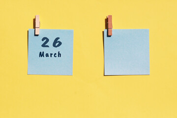 March 26st. Day of 26 month, calendar date. Two blue sheets for writing on a yellow background. Top...