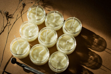 wooden wick candles. Handmade candle from paraffin and soy wax in glass with flowers and leaf on...