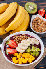 .Brazilian açaí in a bowl accompanied by tropical fruits. Fruit of the Amazon