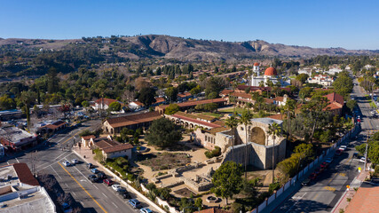 Daytime aerial view of the Spanish Colonial era mission and surrounding city of downtown San Juan Capistrano, California, USA. 
