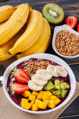 .Brazilian açaí in a bowl accompanied by tropical fruits. Fruit of the Amazon