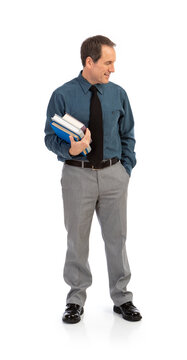 Male Teacher Standing With Stack Of Books Looks To Side