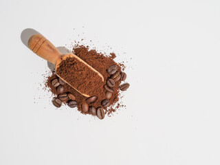 Ground coffee in wooden spoon isolated on white background.