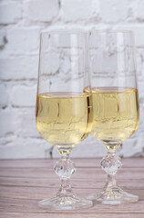 glasses with champagne on white briks background