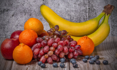 three apples and other fruits on dark wood background