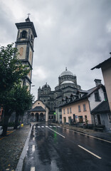 Obraz premium Madonna del Sangue during rain season moody dark cloudy cloud green tress houses church cathedrale 