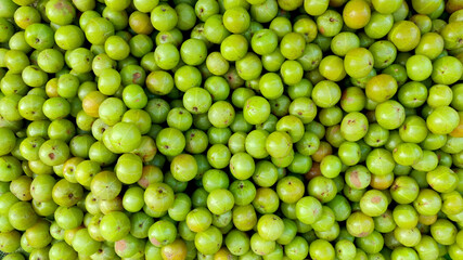 Top Down shot of Green Indian Gooseberries. Lime green berries background or pattern.