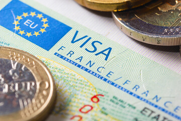 Schengen visa in the passport with a few coins. This sample of the Schengen visa has been put into...