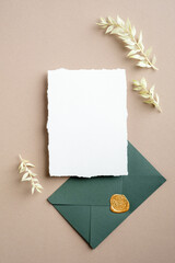 Wedding details card template. Blank paper card and green envelope with dried flowers. Flat lay,...