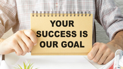 Your success is our goal text on notebook in hands.