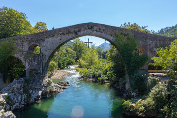 Cangas de Onis, Spain - September 4, 2020: The Roman Bridge of Cangas de Onís, the “Puente Vieyu” or “Puentón”. Medieval stone bridge over the Sella River, Asturias, Spain.