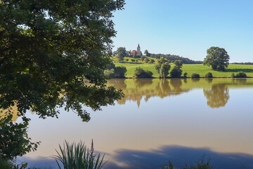 Fototapeta premium pond with a church on a hill 
