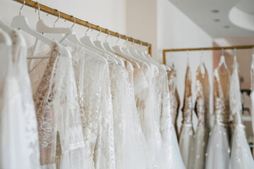 Wedding dresses on hangers in a showroom.