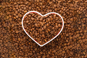 roasted coffee beans in heart shaped plate background