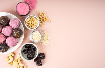 Fototapeta na wymiar Ingredients Homemade pink matcha dragon fruit energy balls, top view, healthy sweets made of nuts and date, prunes, cashew nuts, Pine nuts. Vegeterian diet candy brain sustainable food. Copy space