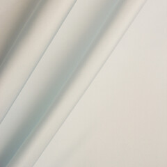 Smooth fabric texture with folds and wawes. Close up silk background