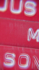 Letras mayúsculas impresas en etiqueta de plástico rojo dymo