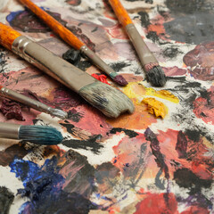Obraz premium Paint brushes on a palette with dried paints.
