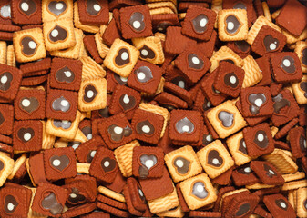 Square cookies with a heart-shaped pattern for background. Top view.