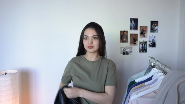 Beautiful Young  Woman is Trying on Leather Jacket & How Jacket Fits Taking Off Jacket