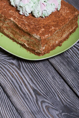 Honey cake decorated with zephyr tulips. On pine boards.