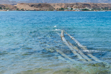 Pipes go to the sea. Environmental or water pollution concept.