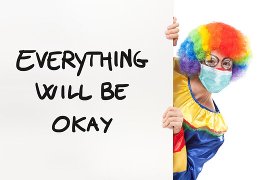 Clown wearing a mask showing panel with text Everything will be okay, coronavirus concept