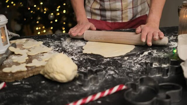 Woman rolling dough for festive gingerbread before christmas at home