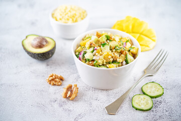 Millet mango avocado cucumber salad in a bowl