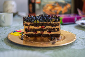 Delicious birhtday cake with fruits on silver plate. Closeup.