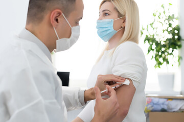 Obraz na płótnie Canvas hand of medical staff injecting coronavirus covid-19 vaccine in vaccine syringe to arm muscle of caucasian man for coronavirus covid-19 immunization, coronavirus covid-19 vaccination,
